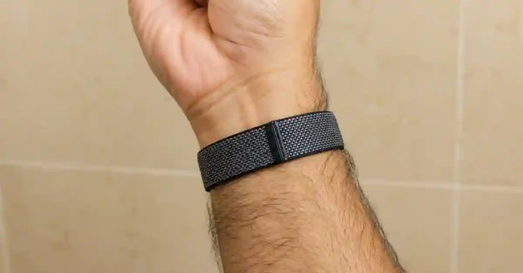 Best Fitness Trackers Under $100 (2026): I Tested 10 — Here's My Pick 15 Fitbit Air screenless fitness tracker pebble sensor clipped into a fabric loop band